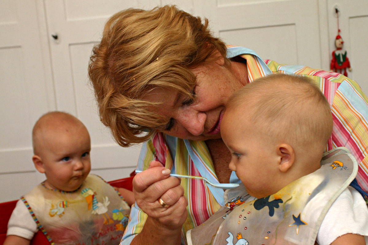 Eine Ehrenamtliche füttert ein Baby